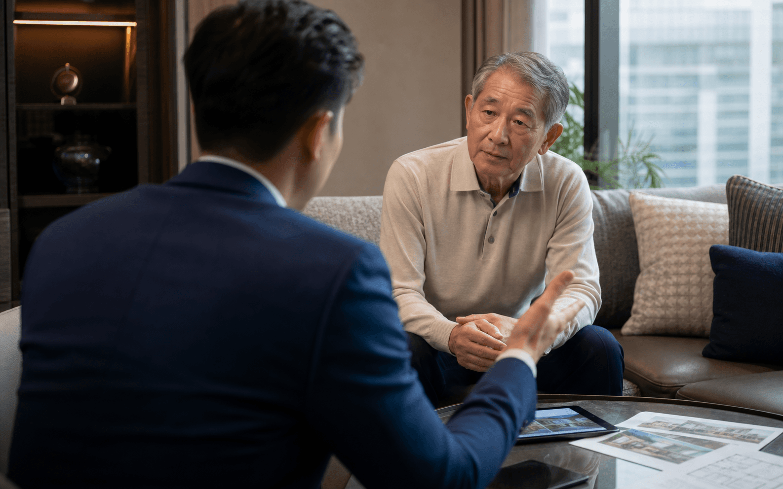 A real estate broker advising an older gentleman client in a calm home office.
